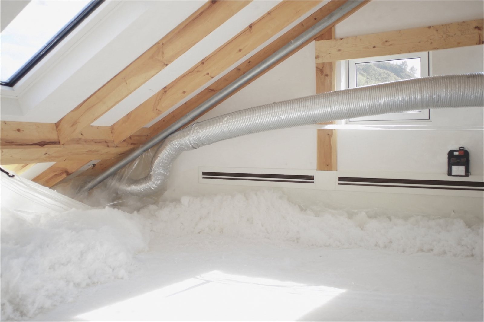 New ductwork and a line set in a bright attic